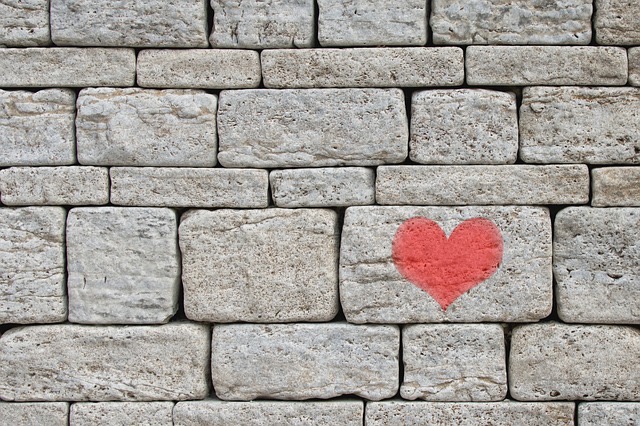 Graue Mauer mit Herz auf einen Stein gemalt
