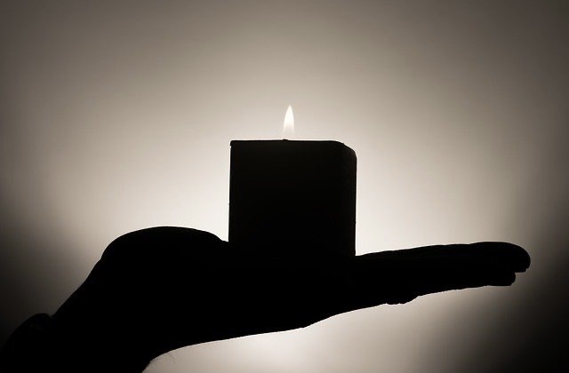 Angezündete Kerze auf Hand nach Feuer-Meditation