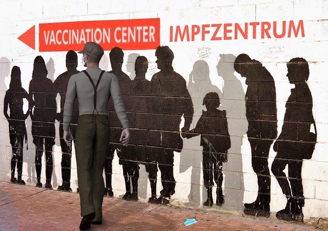 Menschenschlange an Wand als Schattenriss im Impfzentrum