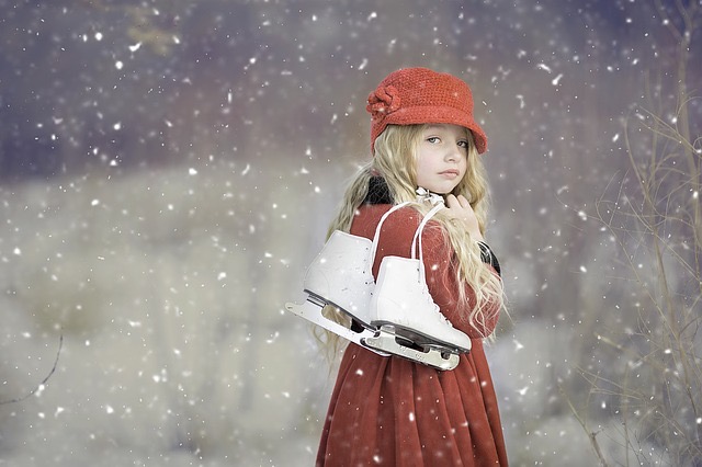 Mädchen, rot und winterlich gekleidet, trägt Schlittschuhe über der Schulter. Es schneit. 