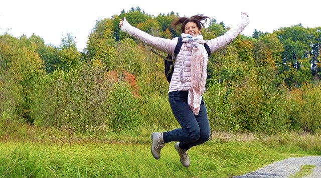 Lebensfreude - Luftsprung einer jungen Frau im Grünen